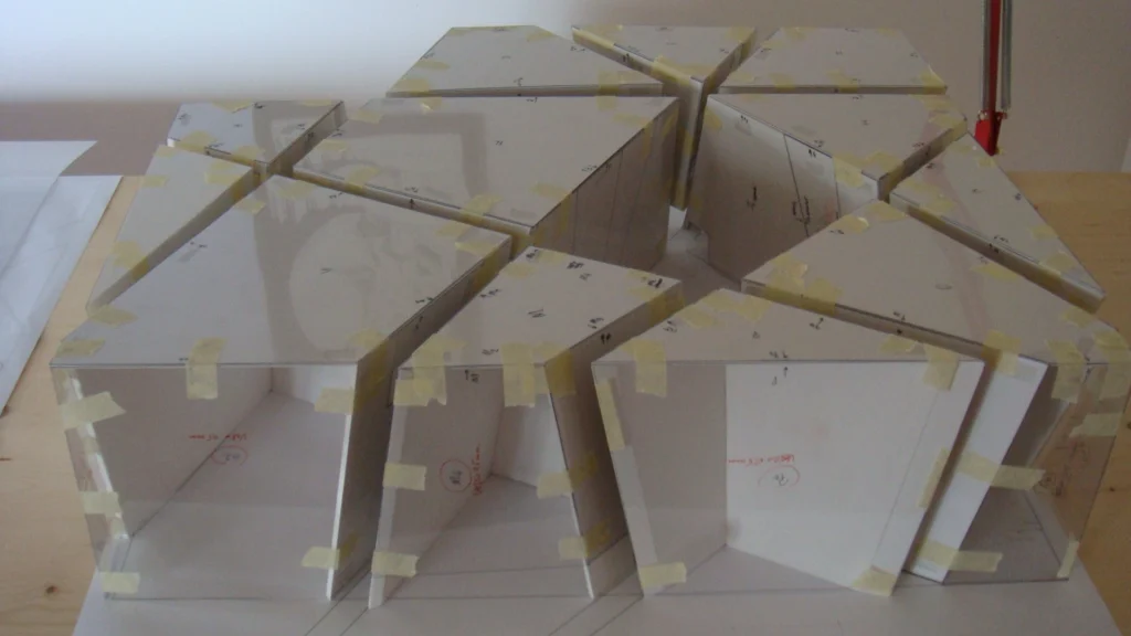Workshop di modellistica: fase di lavorazione finale del plastico di presentazione, posizionamento degli elementi strutturali sulla base.