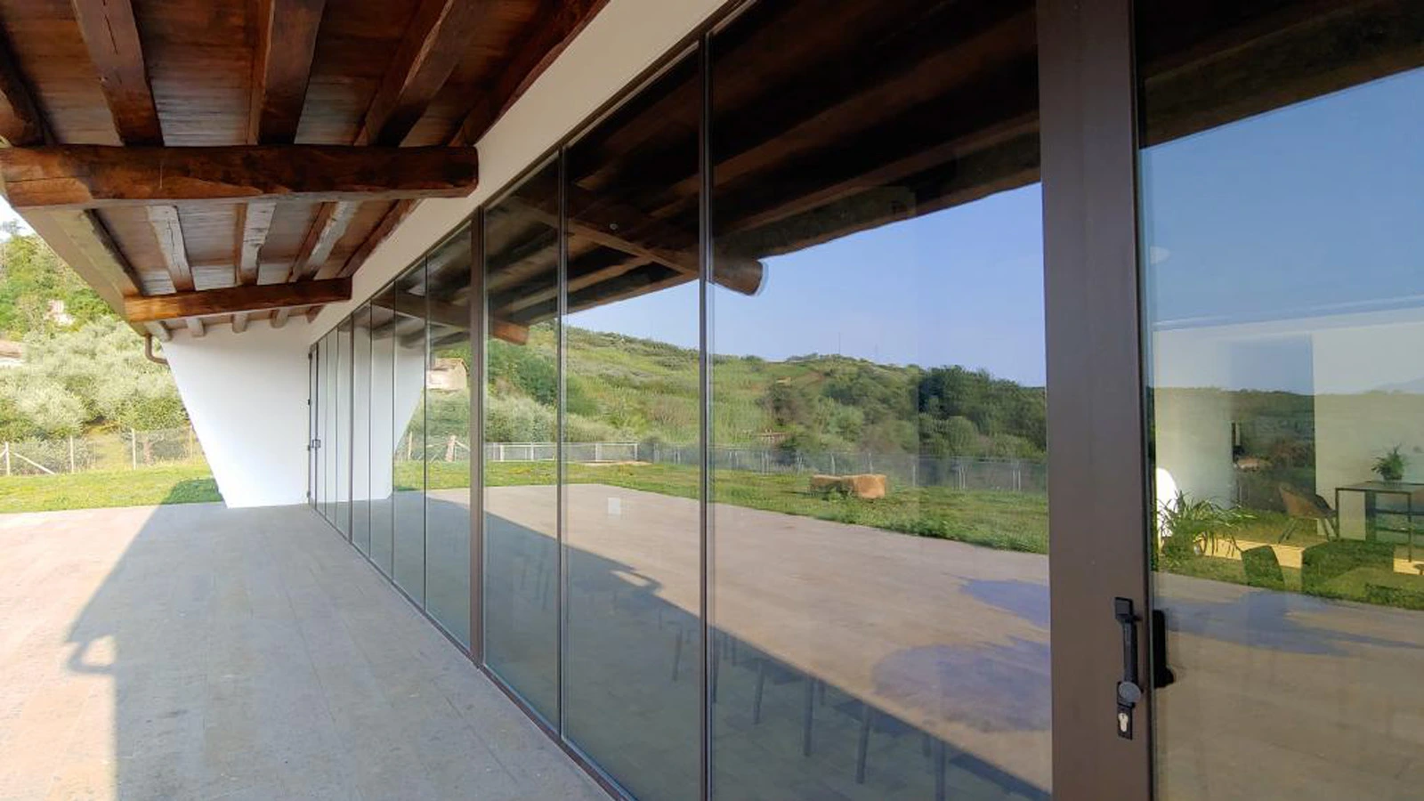 Vista esterna del Casale Coni: esempio di recupero e restauro di un edificio rurale in pietra con serramenti moderni.