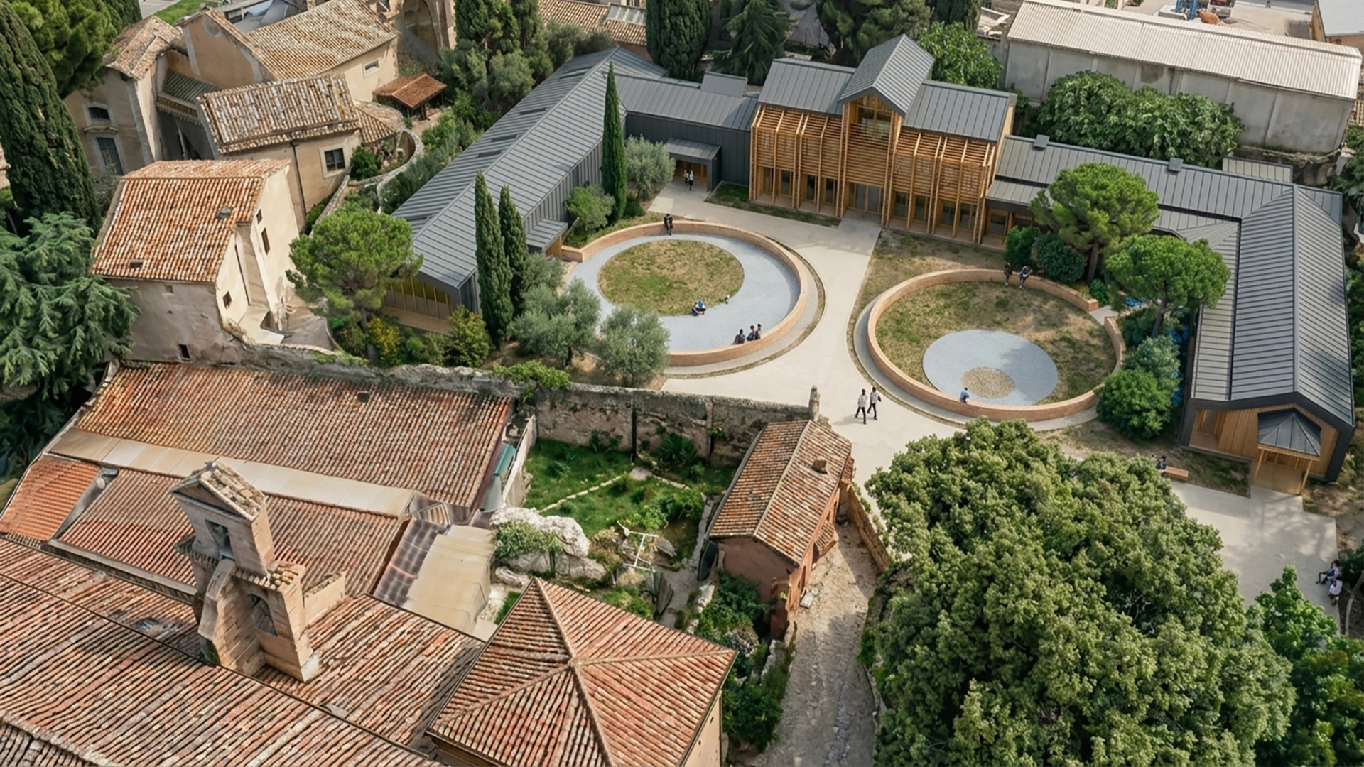 Vista aerea del complesso dell’Asilo San Gregorio al Celio, Roma, con edifici storici e nuovi volumi in legno organizzati attorno a corti verdi.